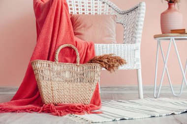 Hasır koltuğu, masası ve çantası olan modern bir oturma odası.