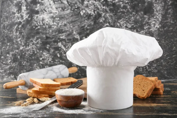 Samenstelling Met Koksmutsen Tafel Tegen Grunge Achtergrond — Stockfoto