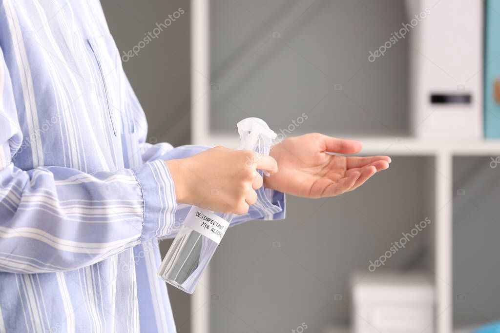 Woman using sanitizer at home