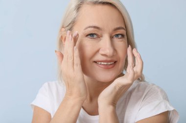 Kontak lensleri açık arkaplanda olan olgun bir kadın