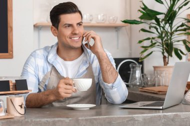 Dükkan sahibi kafesinde çalışıyor.