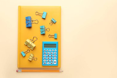 Renk arkaplanında kırtasiye malzemesi olan modern hesap makinesi