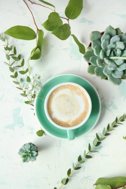 Bir fincan kahve ve arka planda yeşil bitkiler