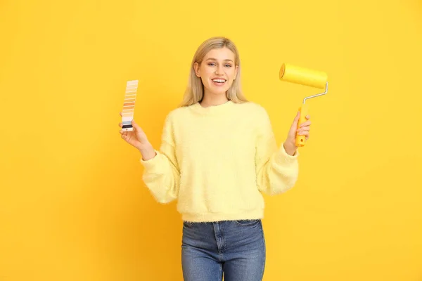 Junge Frau Mit Farbmustern Und Farbroller Auf Gelbem Hintergrund — Stockfoto