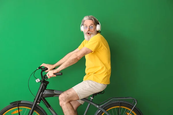Érzelmi Idős Férfi Kerékpárral Fülhallgatóval Színes Háttér — Stock Fotó