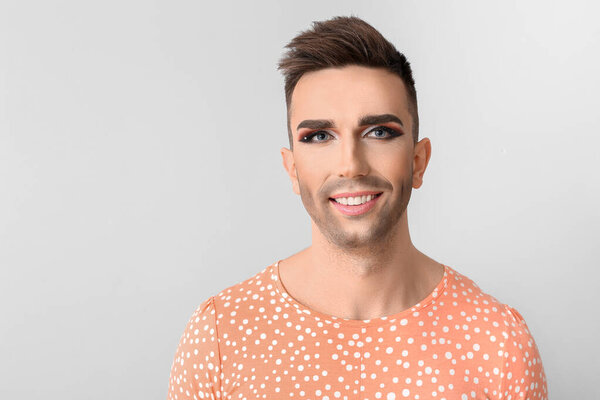 Portrait of young transgender woman on light background