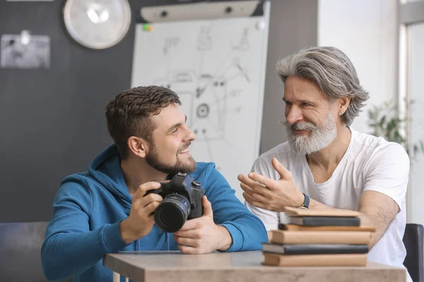 Mentor teaching young photographer in studio