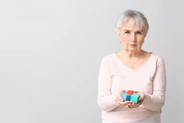 Mulher Idosa Com Deficiência Mental Com Cubos Fundo Cinzento — Fotografia de Stock