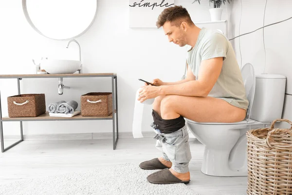 Jovem Com Telefone Celular Papel Higiênico Banheiro Conceito Hemorróidas — Fotografia de Stock