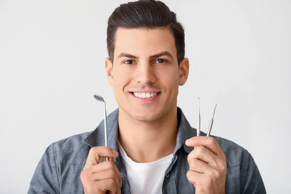 Junger Mann Mit Zahnwerkzeug Auf Hellem Hintergrund — Stockfoto