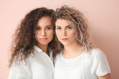 Beautiful young women on color background