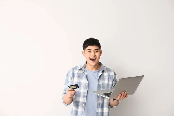 Surpreendido Asiático Homem Com Cartão Crédito Laptop Fundo Branco — Fotografia de Stock