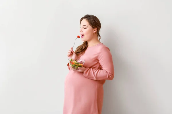 明るい背景に健康的なサラダを持つ美しい妊婦 — ストック写真