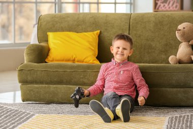 Evde video oyunu oynayan sevimli küçük çocuk.