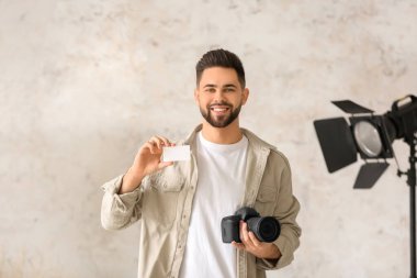 Stüdyoda kartviziti olan bir erkek fotoğrafçı.