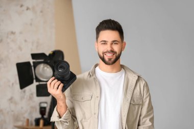 Stüdyoda profesyonel kameralı bir erkek fotoğrafçı.