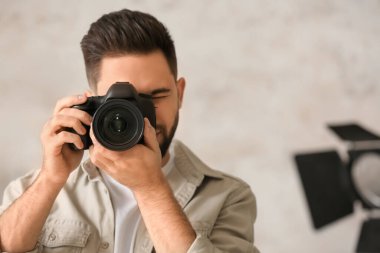 Stüdyoda profesyonel kameralı bir erkek fotoğrafçı.
