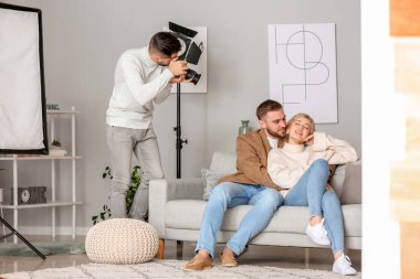 Photographer working with young couple in studio