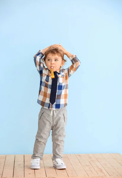 Cute little boy with party decor near color wall