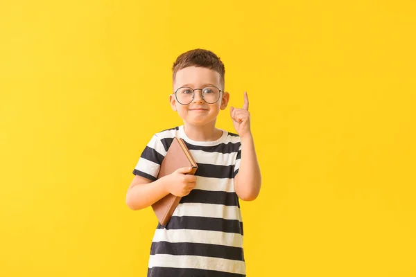 Menino Bonito Com Livro Dedo Indicador Levantado Fundo Cor — Fotografia de Stock