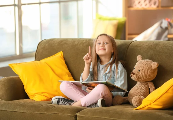 Linda Niña Leyendo Libro Sofá Casa —  Fotos de Stock