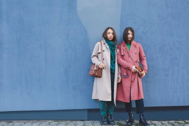 Duvarın yanında şık genç kadınlar.