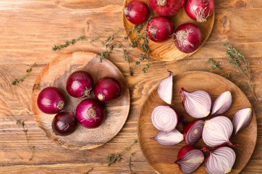 Taze çiğ soğanlı tabaklar ve ahşap kaplamalı otlar.