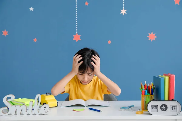 Gestresster Kleiner Junge Macht Hausaufgaben Vor Farbigem Hintergrund — Stockfoto