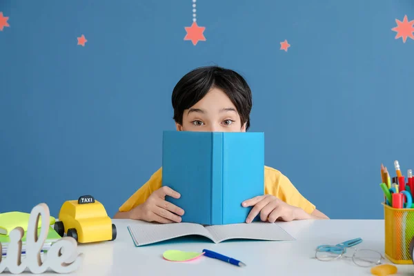 Kleiner Junge Macht Hausaufgaben Vor Farbigem Hintergrund — Stockfoto