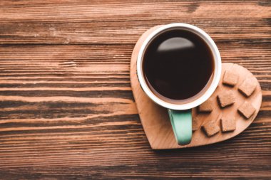 Tahta arka planda şekerli bir fincan kahve.