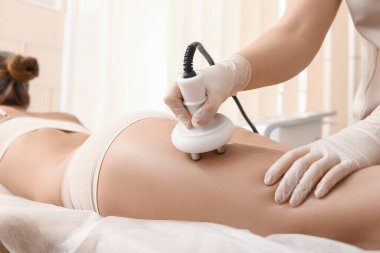 Güzeller güzeli kadın güzellik salonunda anti-selülit masajı yaptırıyor.