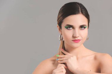 Gri arka planda güzel manikürlü genç bir kadın.
