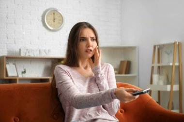 Evde televizyon izleyen genç ve güzel bir kadın.