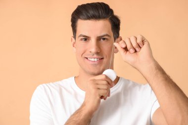 Arka planda diş ipi olan genç bir adam.