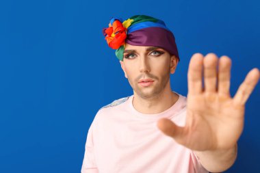 Renkli arka planda dur hareketi gösteren genç transseksüel kadın portresi