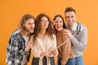 Renk arkaplanında selfie çeken arkadaşlar