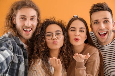Renk arkaplanında selfie çeken arkadaşlar