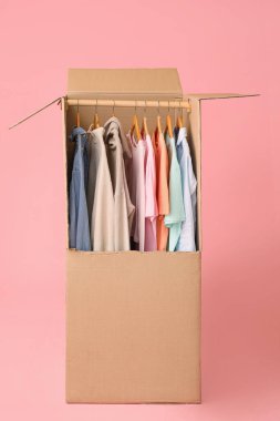 Renkli arka planda kıyafet taşıyan kutucuk taşınıyor