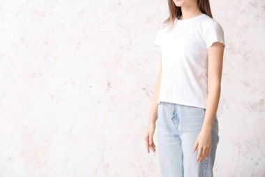 Hafif arka planda şık tişörtlü genç bayan.