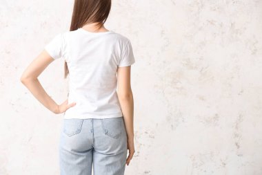 Hafif arka planda şık tişörtlü genç bayan.