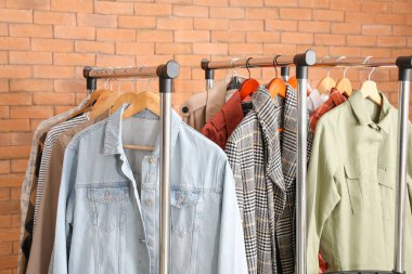 Tuğla duvarın yanında giysilerle dizilin.