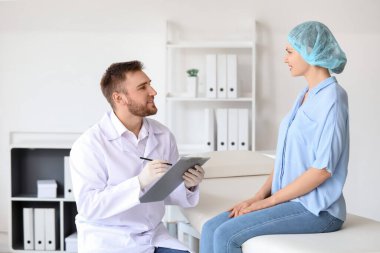 Kadın estetik cerrahı klinikte ziyaret ediyor.