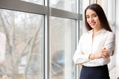 Ofisteki pencerenin yanındaki güzel genç iş kadınının portresi