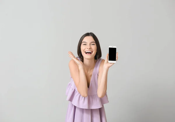 Šťastná Mladá Žena Mobilním Telefonem Šedém Pozadí — Stock fotografie