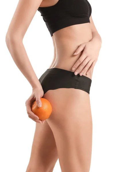 白い背景に橙色の果実を持つ若い女性 セルライトの概念 — ストック写真