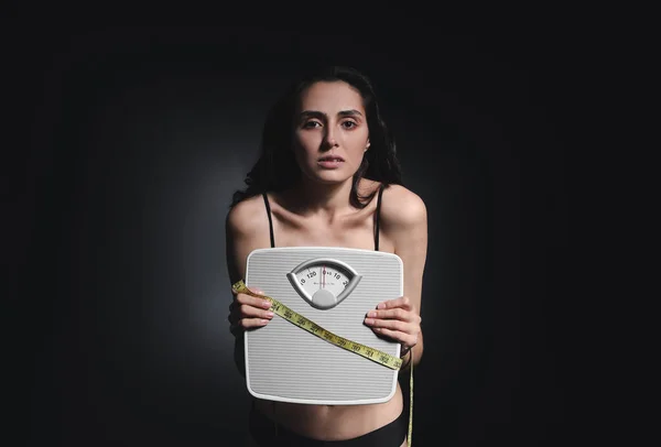 Mulher Doente Com Escalas Fita Métrica Fundo Escuro Conceito Anorexia — Fotografia de Stock