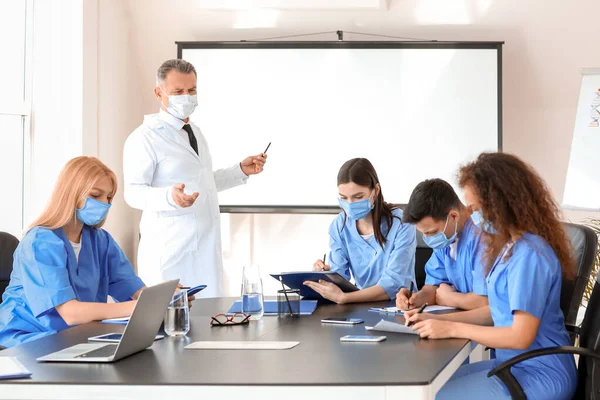 Male lecturer teaching medical students in university