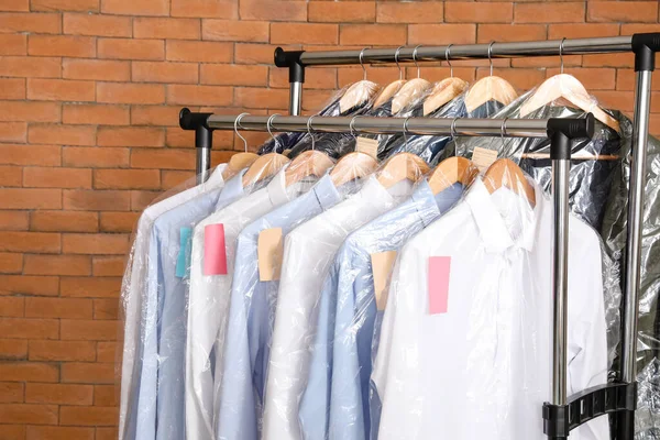 Cremalheira Com Roupas Após Limpeza Seco Perto Parede Tijolo — Fotografia de Stock