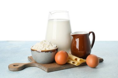 Masada beyaz arka plana karşı farklı süt ürünleri