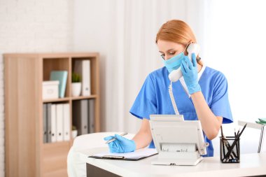 Klinikteki masada çalışan kadın resepsiyonist.